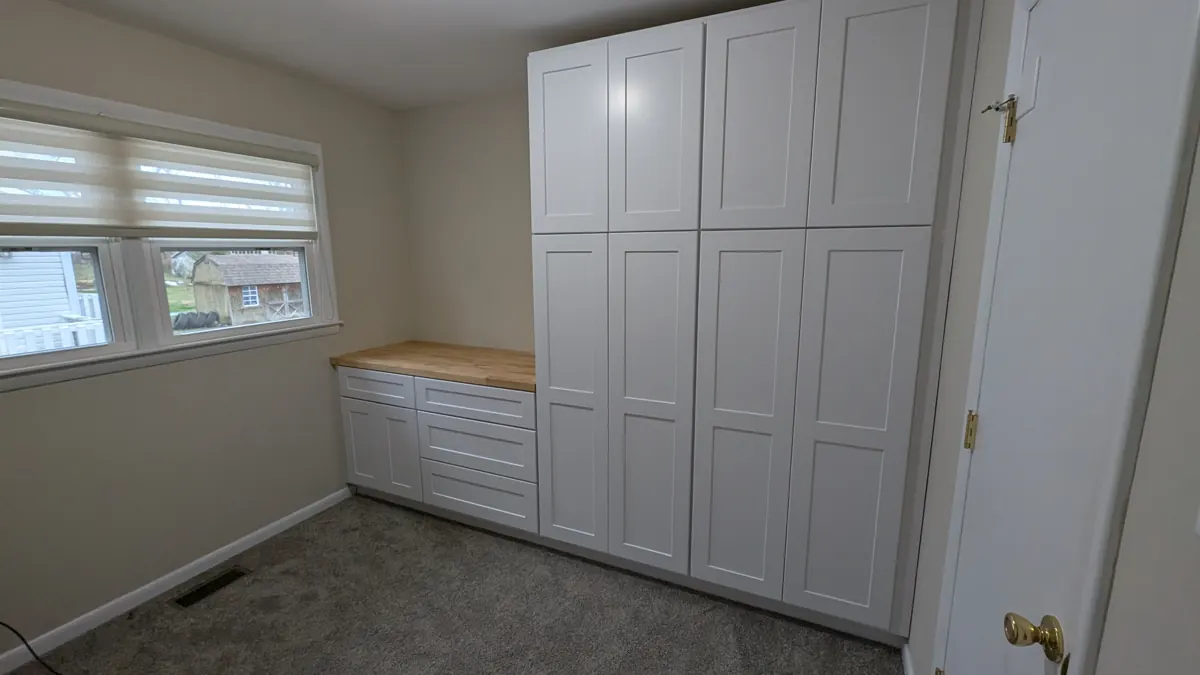 Floor-to-ceiling white built-in cabinets with butcher block counter