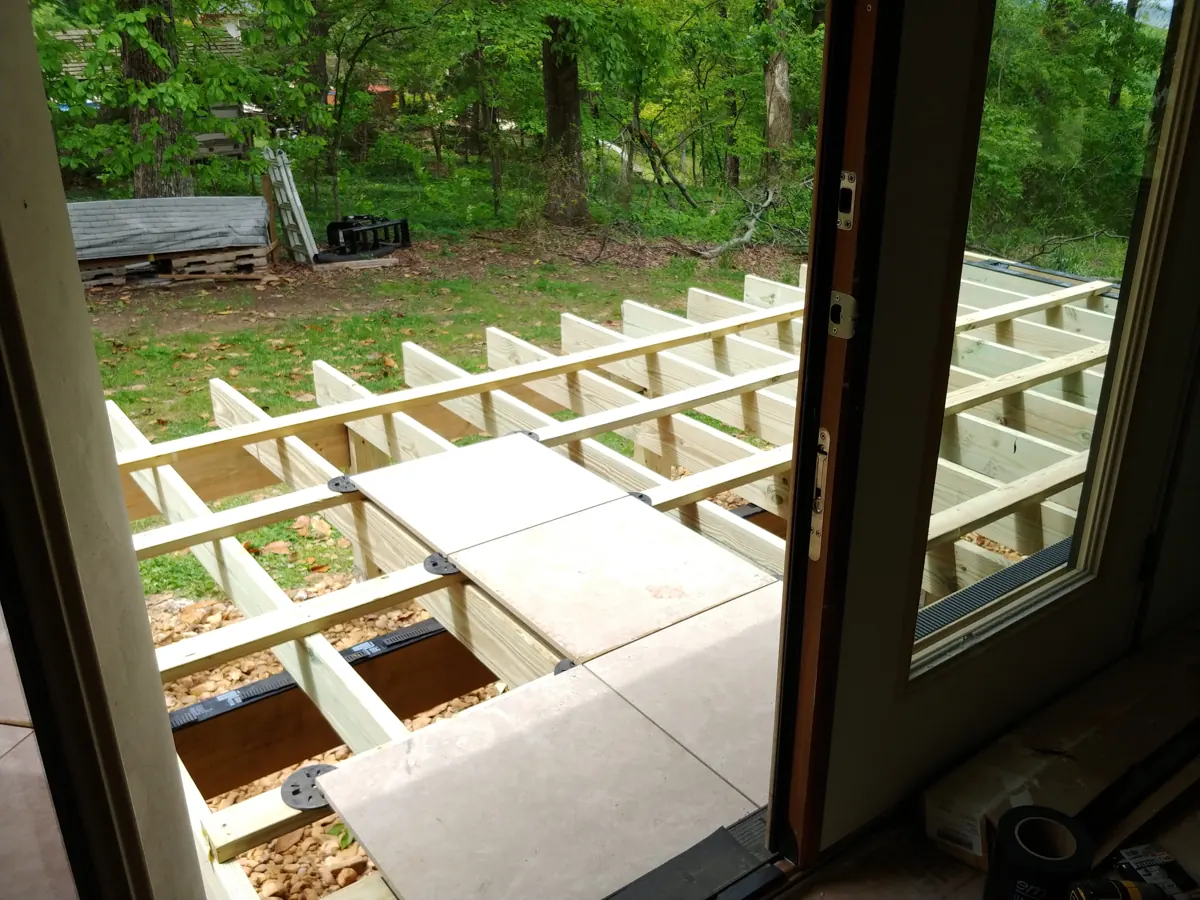 Deck framing with large porcelain tiles being set