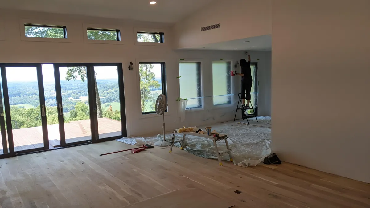 Open great room with new windows and wood floors during renovation