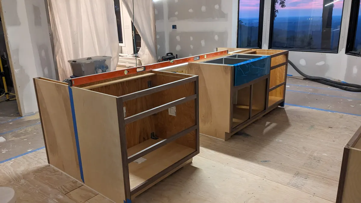 Kitchen island cabinets being leveled during installation