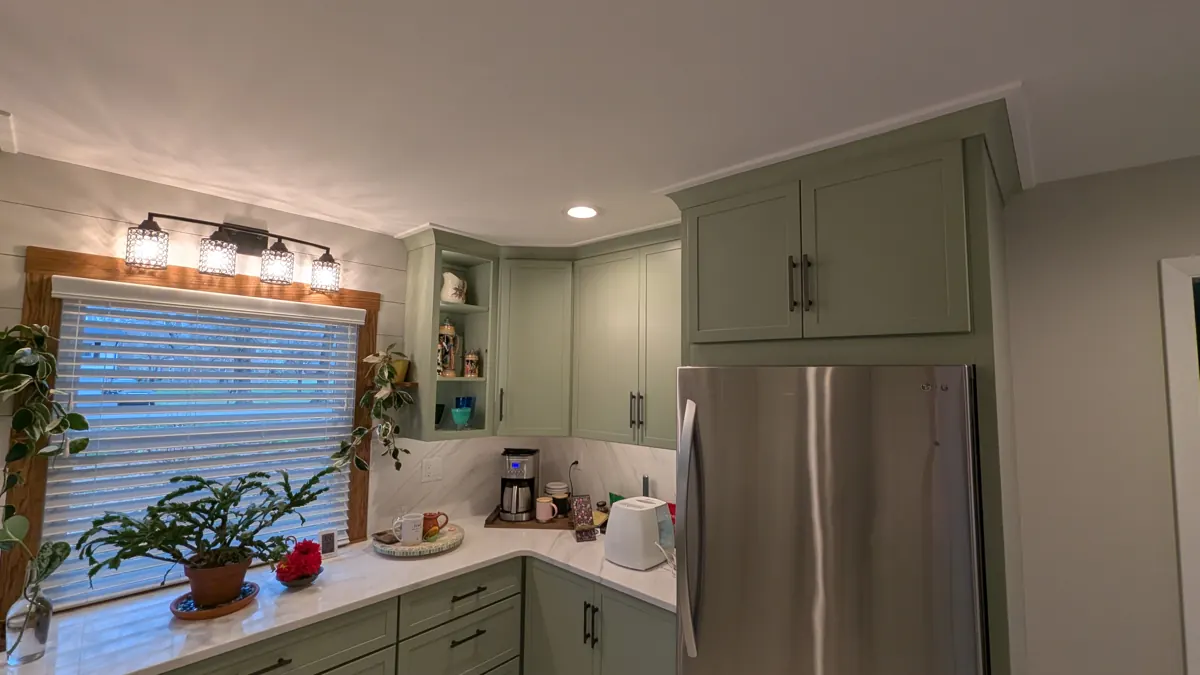 Kitchen with sage cabinets, window lights and stainless appliances