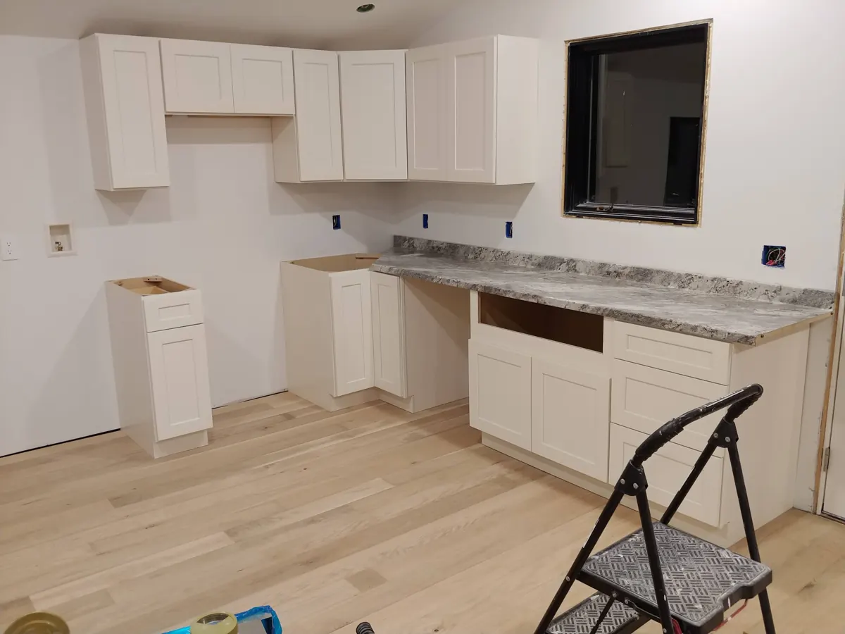 White shaker kitchen cabinets being installed