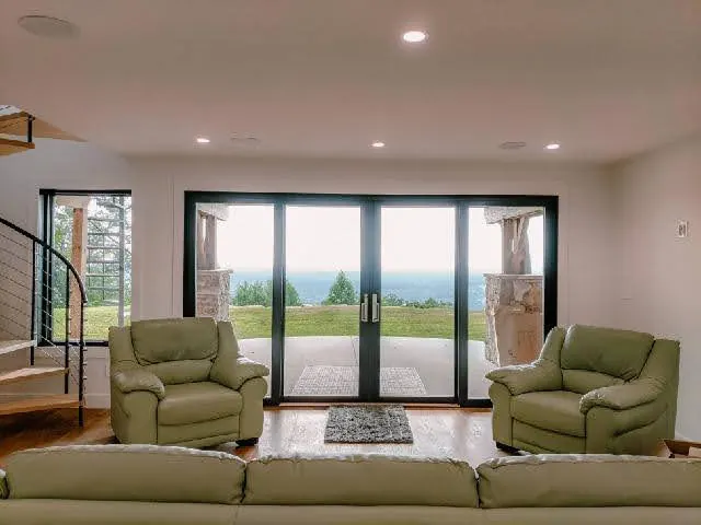 Living room with glass doors opening to a covered porch and valley view