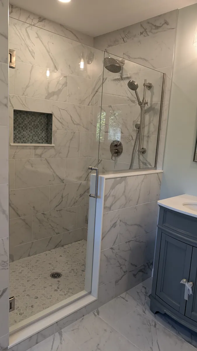 Walk-in shower with marble-look tile, niche and glass panel
